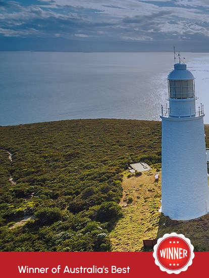 Aerial view of the historic Cape Bruny Lighthouse and its surrounding coastal landscape.