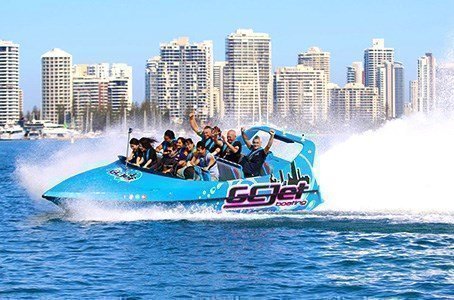 GC Jet boat roaring through the Gold Coast waterways with the city skyline in the backdrop