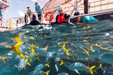 Guest captures a cheeky selfie with the fish life with the view of the pontoon in the backdrop