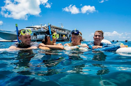 Guest captures a cheeky selfie with the fish life with the view of the pontoon in the backdrop